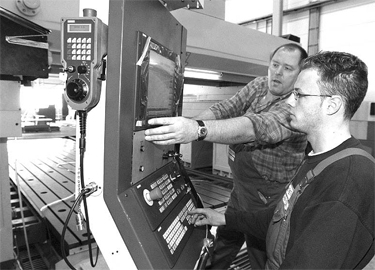 Ausbilder Stefan Niedenführ (42) erklärt Azubi Rudi Seller (21) erste Handgriffe an der neuen Portalfräsmaschine, die zurzeit noch aufgebaut wird.